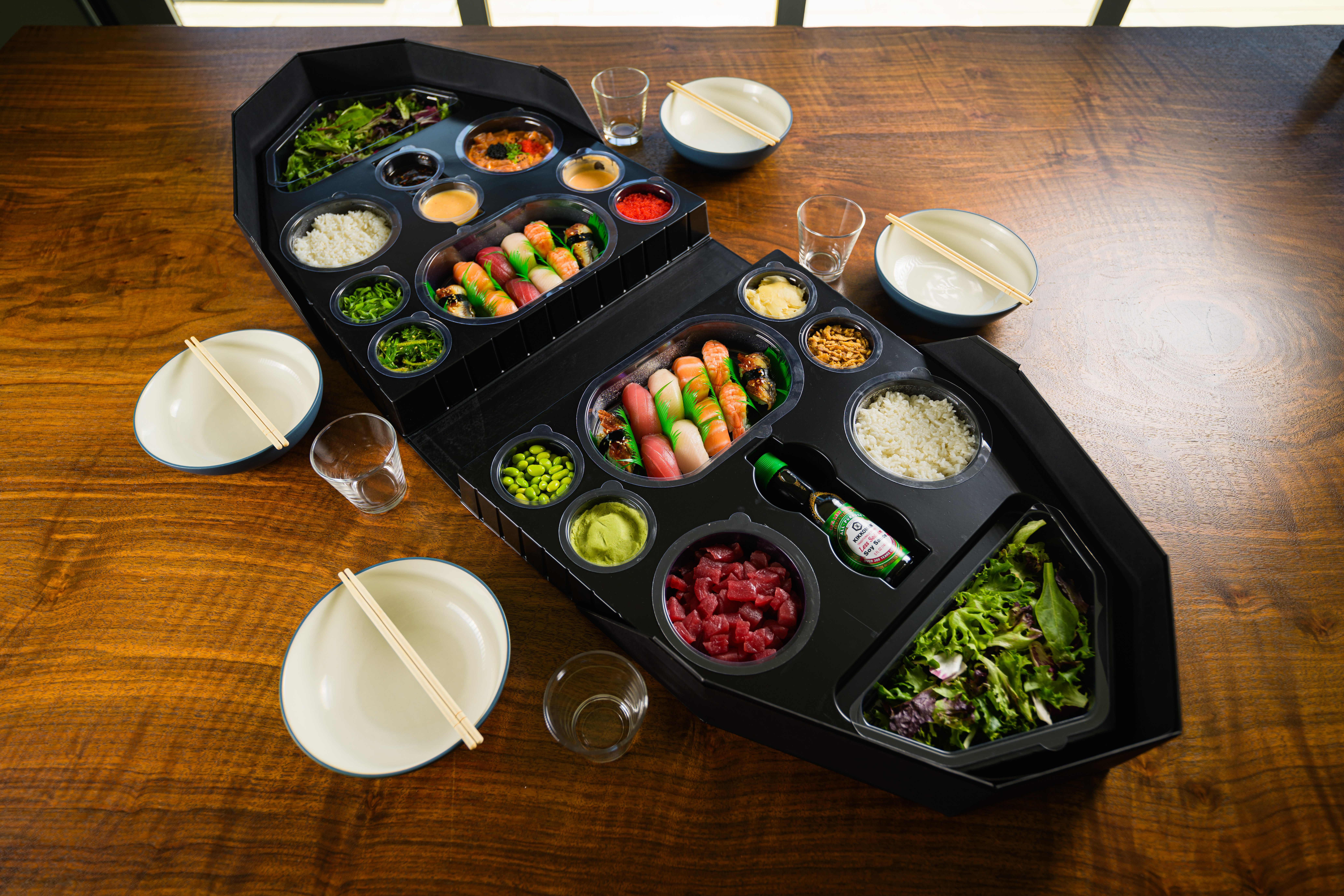 Two combo sushi boats loaded with nigiri and greens