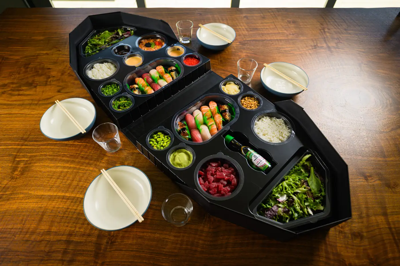 Two combo sushi boats loaded with nigiri and greens