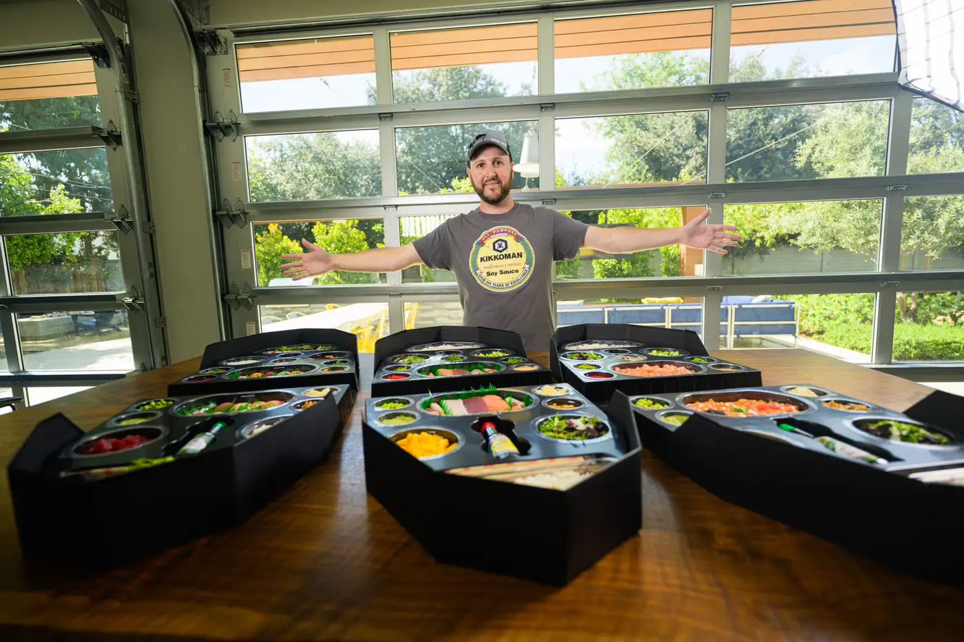Sushi Boat founder Jon Burns with six sushi boats spread across the table